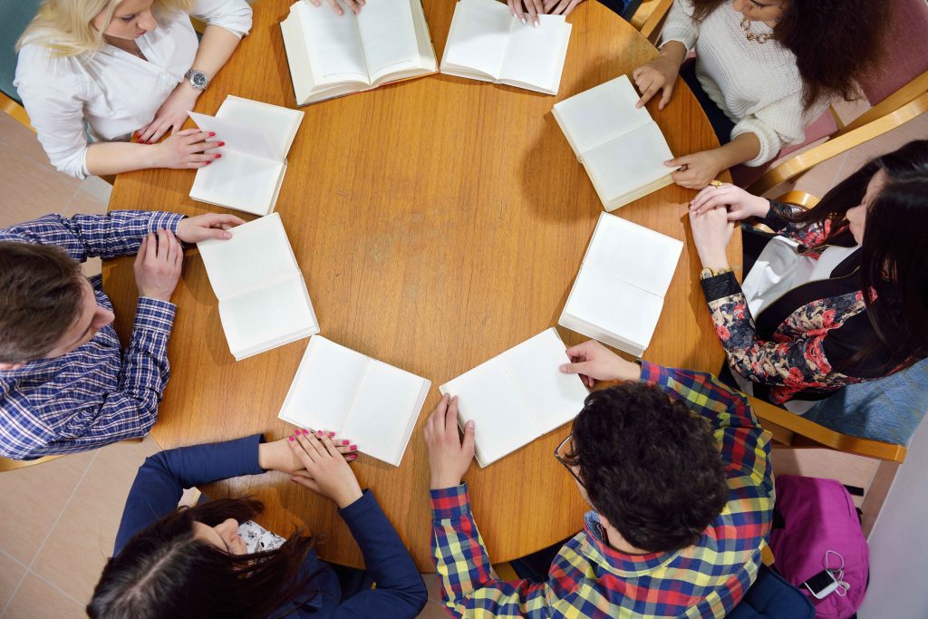 group of teens in circle reading
