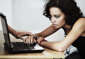 An arm coming out from a from laptop screen grabs the hand of a teen.