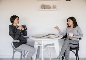 Two women having a thoughtful conversation at a round table