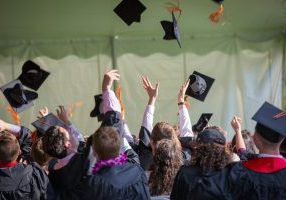 Graduates throwing hats in the air at ceremony.